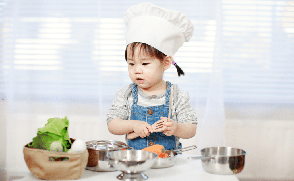 little girl playing make believe chef